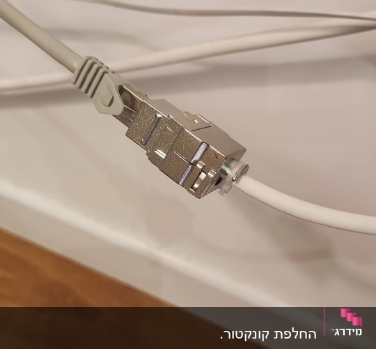 כבל רשת מחובר למחבר מתכת על קיר